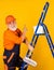 This will be perfect. senior man painter use roller on ladder. painting the wall in yellow. professional painter in