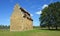 Willington  Dovecote and trees with blue sky and clouds.