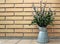 willow buds in an ornamental metallic jug on brick wall background