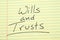 Wills and trusts on a yellow legal pad