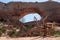 Wilson Arch, a natural sandstone arch located 24 miles south of Moab, Utah. Amazing view looking down into the valley
