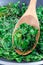 Wilted arugula or rocket salad, preparing a side dish to steak, in frying pan, vertical