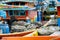 Winches and coiled ropes on colorful fishing boats moored next to each other