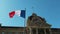 Wind blowing France flag on the mast against blue sky background in front of Palais du Rhin, Place de la Republique, Strasbourg, A