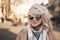 Wind blows lady`s blonde hair and covers her face and sunglasses