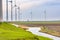 Wind electricity with water channel and old wind mill in background between new technology on the north of Netherlands near Eemsha