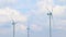 Wind energy turbines renewable electric energy source, under blue sky with white clouds