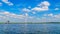 Wind Farm with Two and Three bladed Wind Turbines and a Fishing Boat on the Lake