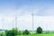 Wind generators turbines electricity and agricultural fields on a summer day with blue sky. Windmills energy production with clean