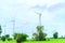 Wind generators turbines electricity and agricultural fields on a summer day with blue sky. Windmills energy production with clean