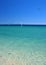 Wind and kite surfers in clear sea with blue sky.