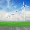 Wind mill power plant in green field and wood plant against blue