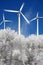Wind mills power generators against winter forest