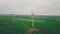 Wind power generators grey sky green field farm