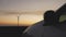 Wind power plants on the background of the car at sunset