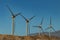 Wind power stations. A row of turbines near the seashore. Wind farm eco field. Eolic park with blue sky in background. Green,