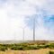 Wind propeller turbines on a high mountain field among the clouds.