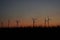 Wind stations in a field against the backdrop of a sunset sky