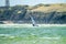 Wind surfer enjoys the beach at Newborough Warren with the Island of Llanddwyn in the background , Isle of Anglesey