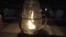 Wind swings a glass cap over candles on a table of street restaurant on the seashore