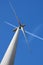 Wind Turbine and Aeroplane Vapour Trail Against a Blue Sky