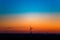 Wind turbine for alternative energy generation in colorful evening sky at blue hour. Dawn after sunset with orange and blue sky