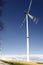 A wind turbine in the blue sky, rotor blades in action