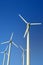 Wind turbine electric generators on a blue sky, vertical