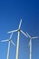 Wind turbine electric generators on a blue sky, vertical