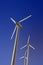 Wind turbine electric generators on a deep blue sky, vertical