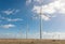 Wind turbine farm over the blue clouded sky