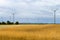 Wind turbine among golden ears of grain crops