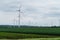 Wind turbine on green fields in summertime. Natural wind power plants and sustainable eco-friendly energy resources