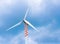 Wind turbine in movement under blue sky and clouds