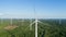 Wind turbine near green forest, beautiful aerial landscape with blue sky. Producing energy in environmentally friendly way. close