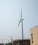 Wind turbine near a large brick tank that says water bio solids