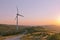 Wind turbine with offroad trail and vibrant sunset