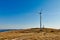 Wind turbine silhouettes against blue sky, hilltop meadow