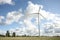 Wind turbine in a sunny day with blue sky and clouds. Wind farm eco field. Green ecological power