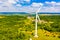 Wind turbine surrounded by green forest. Amazing landscape. Summer time. Alternative energy concept