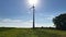 Wind turbine tower with long shade against sun light