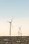 Wind turbine tower with sunset sky background in counter side, winter season..