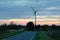 Wind turbine by a winding road at late evening