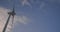 Wind turbine windmill turning in a blue sky with clouds