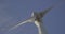 Wind turbine windmill turning in a blue sky with clouds