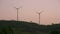 Wind turbine windmills on green hill under sunset sky in Portugal