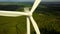 Wind turbines close-up on forest on cloudy day