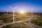 Wind turbines in a field, wind turbine farm sundown, Wind Power Turbines in a rural area, Tracking shot of energy producing wind