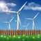 Wind turbines on a grass field behind a wooden fence