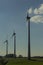 Wind turbines on green field with path. Green â€“ ecological, renewable and sustainable alternative to traditional sources of